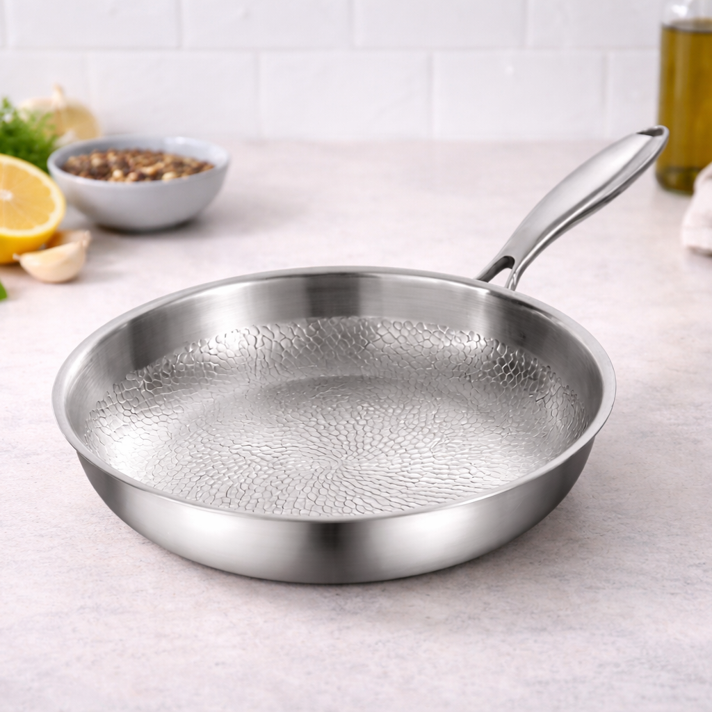 Pure titanium frying pan with textured cooking surface on a kitchen worktop, styled with fresh ingredients